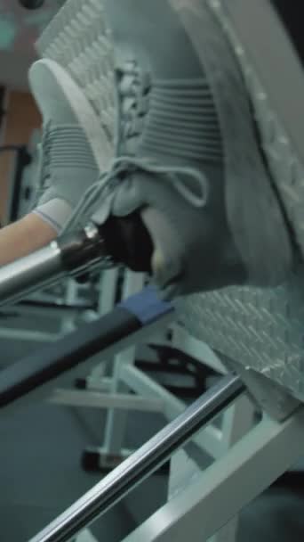 Vertikální záběr sportovce s protetickou nohou cvičení na noze lis stroj v moderní tělocvičně nebo fitness centrum. Přizpůsobit člověka s tělesným postižením dělá silový trénink pomocí profesionálních sportů - Záběry, video