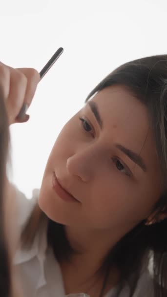 A cosmetologist make-up artist works in a salon. Delve into the world of eyebrow makeup as an art. Every moment in this vertical video is a play of shadows and contours, creating volume and expression - Footage, Video