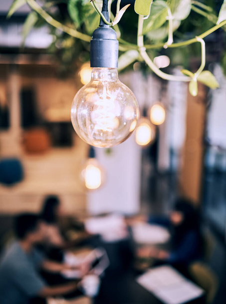 Sitzungssaal, Glühbirne und Brainstorming-Treffen im kreativen Unternehmen mit umweltfreundlicher Glühbirne. Beleuchtung, Strom und Solarenergie mit Arbeitern bei Startup-Diskussion mit hellem und unscharfem Hintergrund. - Foto, Bild