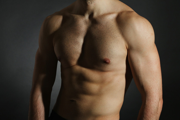 Muscle young man on dark background - Foto, imagen