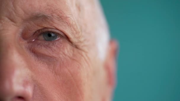 Een close-up van het oog. Oude man met lichtblauwe ogen. Knipperende Oog. Close-up - Video