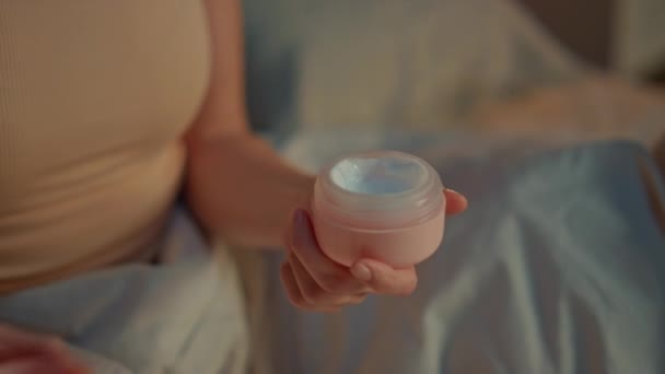 Woman hands opening cream at evening bedroom close up. Unrecognizable girl trying nourishing lotion in round jar at skincare routine. Unknown lady applying cosmetics to palms skin at bedtime home. - Footage, Video