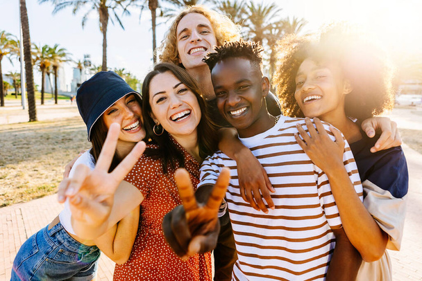 Porträtgruppe junger multikultureller trendiger Freunde, die vor Palmen in die Kamera schauen. Outdoor-Foto von verschiedenen glücklichen Menschen, die Spaß im Sommer haben. Schwarzer im Fokus - Foto, Bild