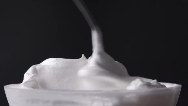 A séf összekeveri a tejszínhabos tojásfehérjét cukorral és kanállal keveri, desszertkészítési folyamat, közelkép az ételről - Felvétel, videó