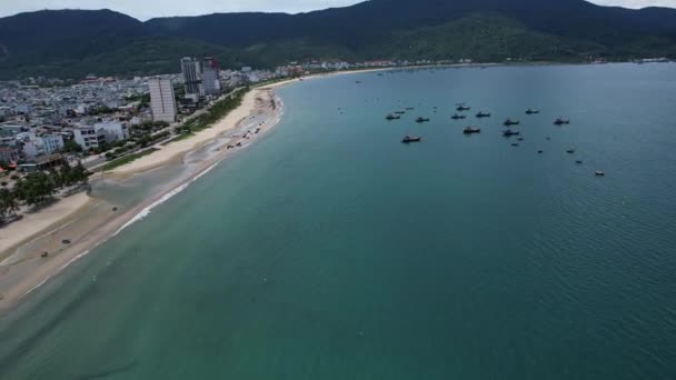 Een schilderachtige luchtfoto van een strand en een lichaam van water met een stad op de achtergrond, presentatie van de azuurblauwe lucht, natuurlijk landschap, en kust- en oceanische landvormen 5K uitzicht Da Nang Vietnam Azië - Video
