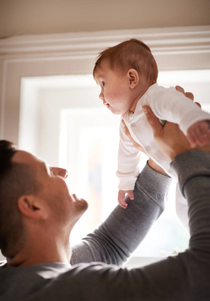 Father, baby and home with bonding, love and support together with family care and development. Dad, smile and young child in a house with parent playing with newborn and happy about infant growth. - Photo, Image
