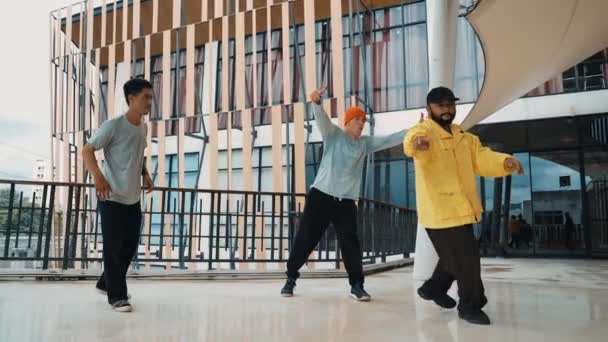 Grupa hipsterów przesuwa się do hip-hopowej muzyki w centrum handlowym. Umiejętny tancerz break wykonuje taniec b-boy będąc otoczony wielokulturowym przyjacielem lub grupą tancerzy. Odkryty sport 2024. hiphop. - Materiał filmowy, wideo
