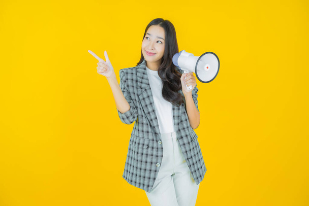 Porträt schöne junge asiatische Frau lächeln mit Megafon auf farbigem Hintergrund - Foto, Bild