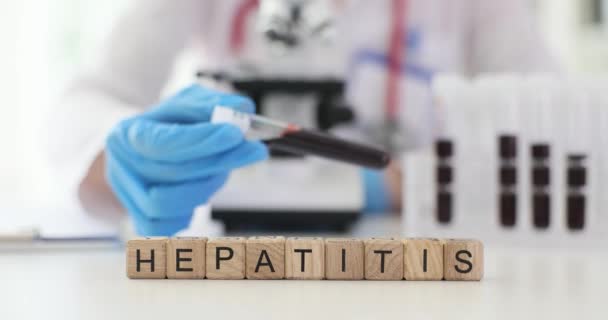 Tesztcső vérrel hepatitisre egy orvos kezében a laborban. A vírusos hepatitis laboratóriumi diagnózisa - Felvétel, videó