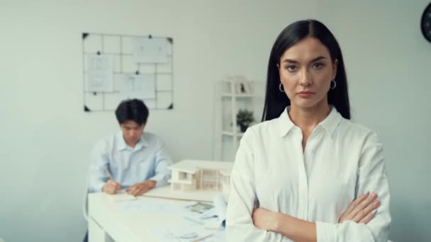 Closeup of female professional architect engineer cross arms with confident while skilled coworker focus on drawing blueprint at table with house model. Creative living and design concept. Immaculate. - Footage, Video