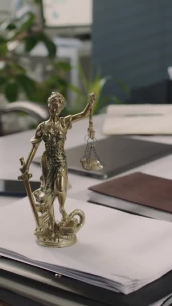 No hay personas imágenes verticales de bronce Lady Justice estatuilla en la pila de documentos en la mesa de la oficina en el bufete de abogados - Metraje, vídeo