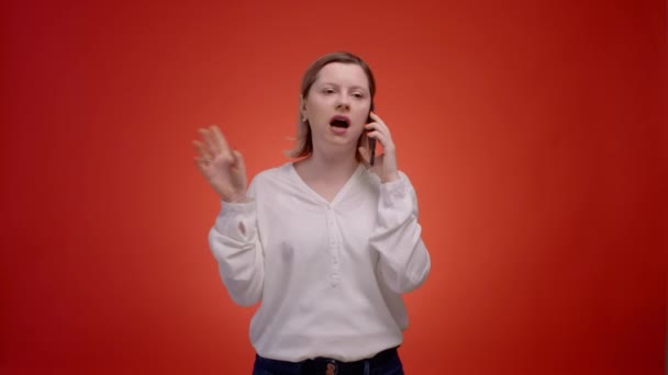  woman talking by phone on a red background, the customer explains what wants to order. Conversation with call center representative. - Footage, Video