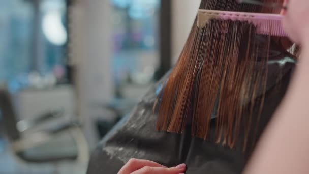 Κοντινό πλάνο των κομμωτών Ψαλίδι Κοπή μια γυναικεία μαλλιά: Δημιουργώντας ένα κομψό και μοντέρνο χτένισμα σε ένα σαλόνι ομορφιάς, επαγγελματική διαδικασία κομμωτικής. Υψηλής ποιότητας 4k πλάνα - Πλάνα, βίντεο