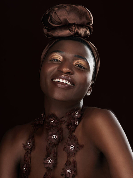 Mosoly, csomagolás és portré fekete nő a stúdióban a divat, a természetes szépség és a smink sötét háttér. Boldog, kozmetikai és afrikai modell hagyományos fejkendővel, kiegészítőkkel vagy csillogással. - Fotó, kép