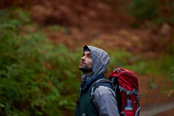 Homem, mochila e caminhadas na floresta para zen com montanhas para viajar no ambiente para a liberdade. Pessoa masculina, bunker subterrâneo e guerra na Ucrânia com preocupação por segurança, militar e pensamento. - Foto, Imagem