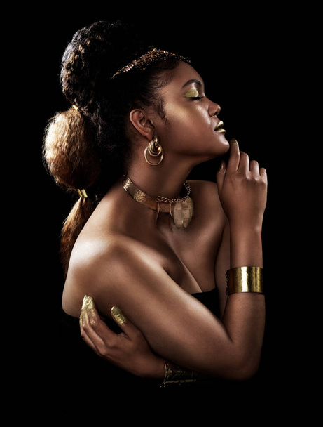 Χρυσό, προφίλ και μαύρη γυναίκα με κοσμήματα για την πολυτέλεια, τη μόδα και πλούσια με στέμμα για την ομορφιά σε σκούρο φόντο. Αφρικανική βασίλισσα, λάμψη και υπερηφάνεια για τον πολιτισμό, τον πλούτο και τη βασιλεία με φόντο στούντιο. - Φωτογραφία, εικόνα