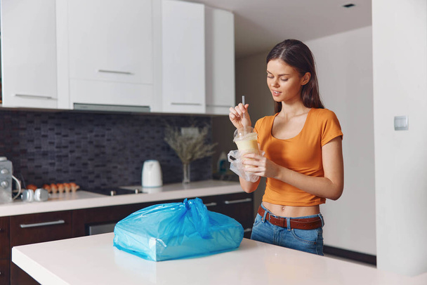 Mutfakta elinde plastik torbayla duran, yemek hazırlayan ve yiyecek hazırlayan bir kadın. - Fotoğraf, Görsel