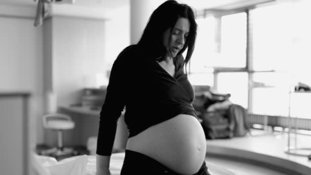 Escena dramática de una mujer embarazada sentada junto a la cama en el hospital con contracciones que luchan con el dolor durante el pre-parto, respirando profundamente sufriendo durante el parto en monocromo - Imágenes, Vídeo