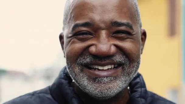 Lächelnder Afroamerikaner in den Fünfzigern mit grauen Haaren, Porträt in Großaufnahme im urbanen Straßenbild - Filmmaterial, Video