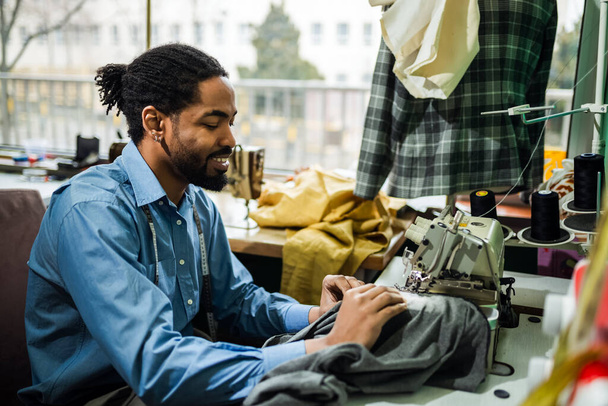 Африканський американський чоловік дизайнер моди шиє на старовинній швейній машині. - Фото, зображення