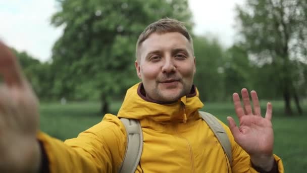 Voyage, homme barbu caucasien debout dans le parc naturel en utilisant un téléphone mobile. Portrait de jeune touriste souriant faisant un selfie ou un appel vidéo à fond vert forêt jungle.  - Séquence, vidéo