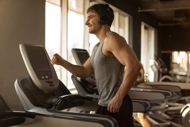 Чоловік тренується на біговій доріжці в спортзалі, бігає чоловіком, займається спортом на сучасному обладнанні в фітнес-клубі - Фото, зображення