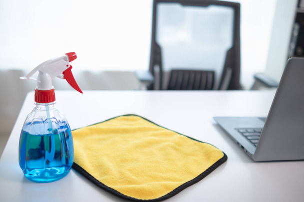消毒剤ベースのクリーニングソリューションは,オフィスのインテリアや家具の表面をきれいにするためにスプレーボトルに用意されています. 契約の概念 クリーナーを雇い,消毒剤を噴霧する - 写真・画像