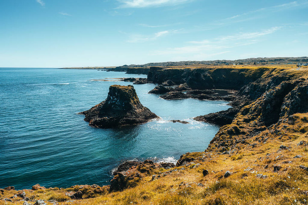 Wybrzeże naturalne bazaltowej formacji skalnej na wybrzeżu w wiosce rybackiej Arnarstapi na półwyspie Snaefellsnes, Islandia - Zdjęcie, obraz