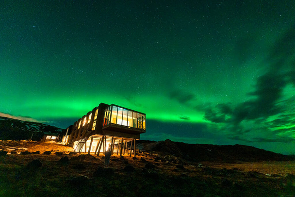 Bela vista panorâmica de Aurora boreal, luzes do norte brilhando sobre hotel de luxo no monte Hengill no inverno em Nesjavellir, Islândia - Foto, Imagem