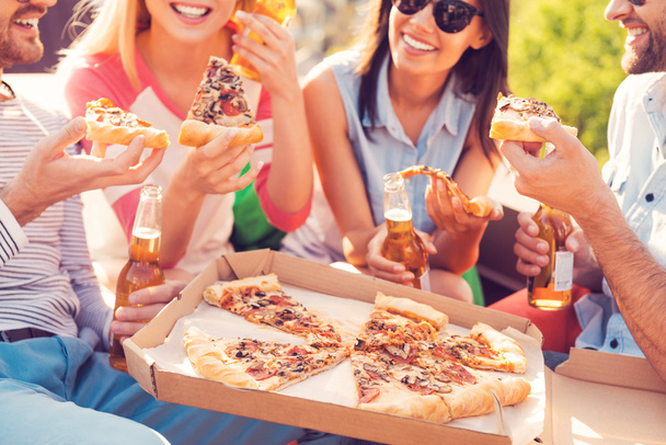 люди їдять піцу і п'ють пиво
 - Фото, зображення
