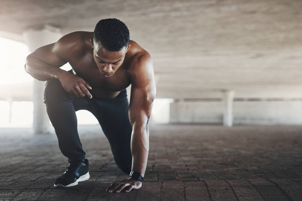 Black man, athlete and outdoor or start exercise with muscle in parking garage for cardio, fitness or strength. Male person, ground and shirtless for summer run is sportswear, wellness or training. - Photo, Image