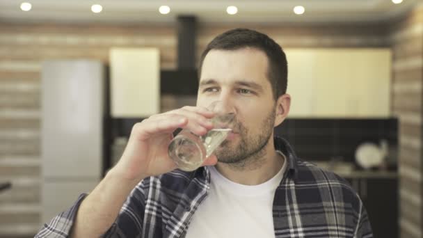 Ruhige kaukasische Männchen, die Glas halten, Wasser trinken und zu Hause in der Küche Zahnschmerzen haben. Gesundheitswesen, Zahnheilkunde Konzept. Zeitlupe - Filmmaterial, Video