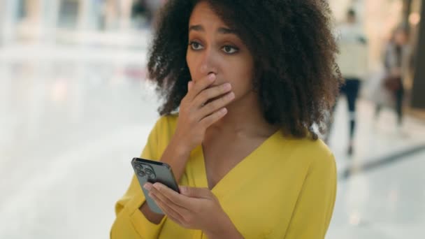 アフリカ系アメリカ人不幸な女性 スクリーン 携帯電話 スマートフォン 悪いニュース 損失 失敗 混乱 女性 電子ガジェット 問題 トラブル 間違い ストレス フラストレーション 悲しい - 映像、動画