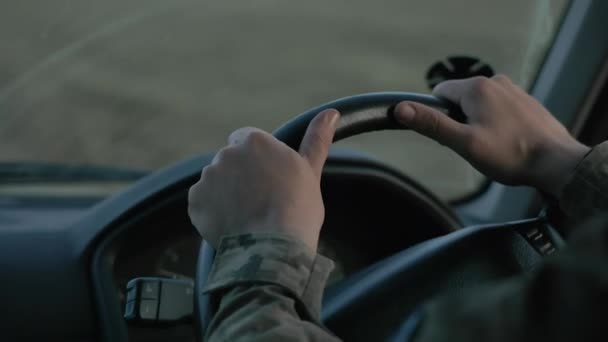 Soldier of the Ukrainian army. Close-up of a soldiers hands on the steering wheel, driving a vehicle at twilight - Footage, Video