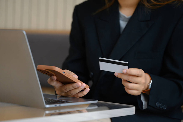 Jovem empresária com cartão de crédito fazendo compras on-line em seu smartphone. - Foto, Imagem
