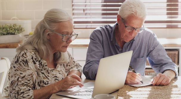 Пожилая пара, ноутбук и кухня для исследований, финансовый бюджет и онлайн инвестиции для оплаты ипотеки в пенсии. Мужчина, женщина и серьезные с технологией и документами или планирование интернет-банкинга. - Фото, изображение