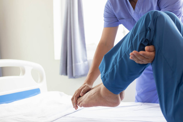 Doctors are examining patient muscle injuries and doing physical therapy for patient to move muscles so they can be used regularly because physical therapy will help strengthen muscles and blood flow. - Photo, Image