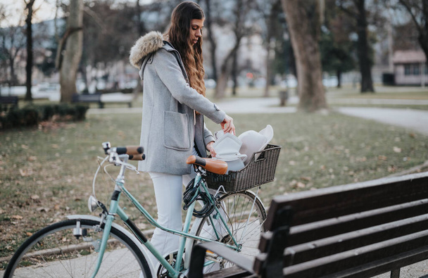 Egy üzletasszony okos alkalmi ruhában biciklivel egy városi parkban, ami egy környezetbarát ingázást testesít meg.. - Fotó, kép