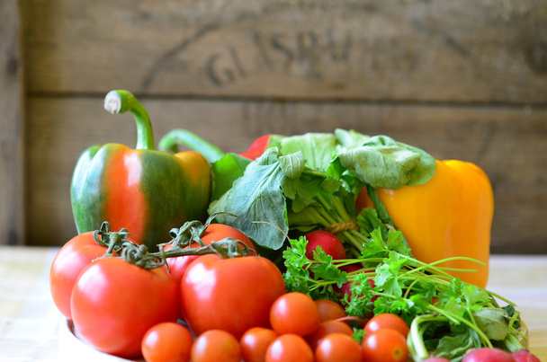 Tomates, rábanos, pimientos, perejil y canasta de mimbre
 - Foto, imagen