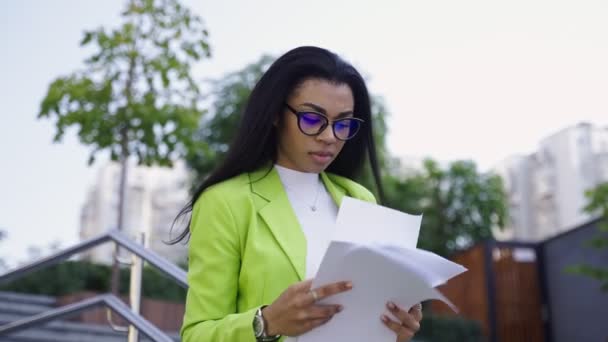 Amerikanische Geschäftsfrau liest Dokumente und überprüft die Uhrzeit. Zeitlupenvideo. Geschäftskonzept - Filmmaterial, Video