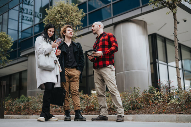 Drei Unternehmer führen vor einem modernen Bürogebäude ein produktives Geschäftsgespräch. - Foto, Bild