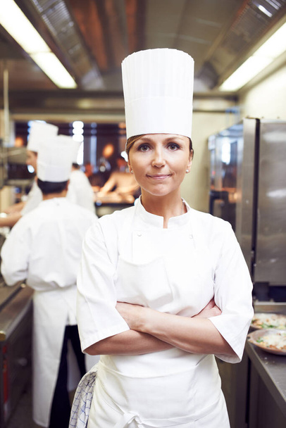 Restaurant, pride and portrait of woman in kitchen for hospitality, service and cuisine. Fine dining, confidence and chef with arms crossed in food industry for catering, job and career in Denmark. - Photo, Image