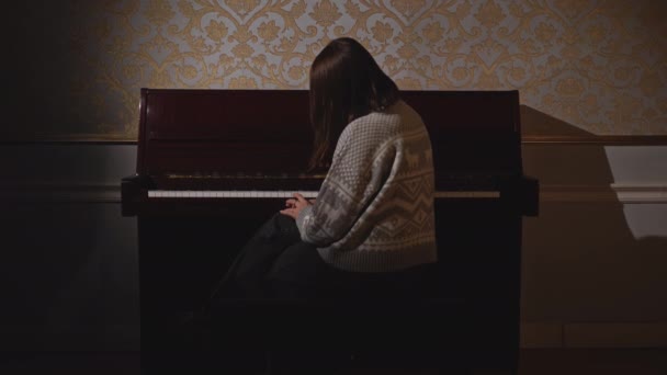 レトロなインテリアアパートで古いピアノを弾いている女性. メディア。 楽器を演奏する人 - 映像、動画