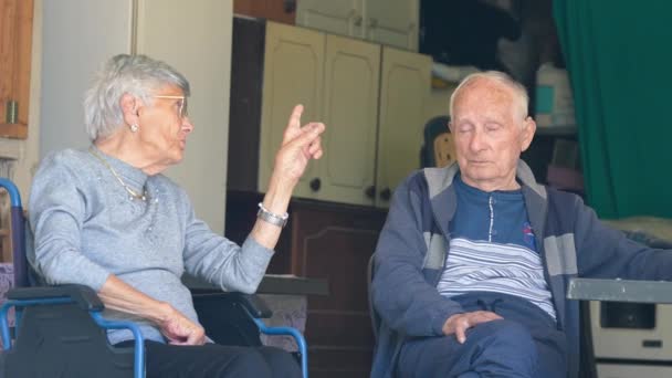 Een bejaard echtpaar dat thuis zit en praat over het leven en ervaringen. - Video