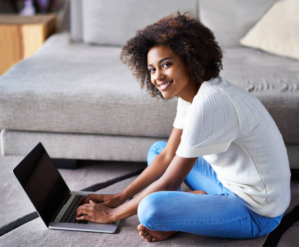 Úsměv, laptop a portrét ženy na podlaze, pracující na kreativním projektu na volné noze v obývacím pokoji. Happy, technologie a africké ženské návrhářky psaní na počítači pro výzkum koberce v bytě - Fotografie, Obrázek