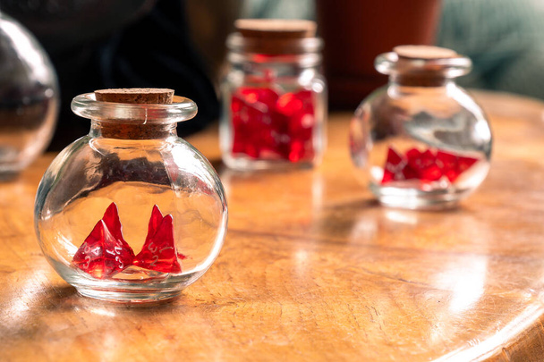 Kolme lasipurkkia punaisella nopalla, huolellisesti järjestetty hyvin kuluneet puinen pöytä, joka tarjoaa vilauksen pelaajan vintage kokoelma - Valokuva, kuva