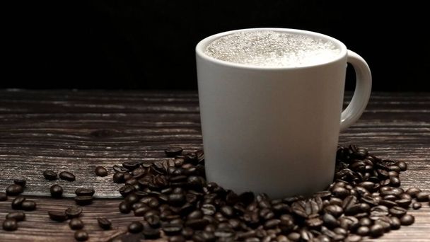 Macchina da caffè che riempie il caffè caldo aromatico in a tazza con sfondo nero. Caffè caldo o espresso sta versando in tazza di caffè bianco cadere in acqua bollita con sfondo nero separato. Comestibile. - Foto, immagini