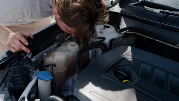 Механик автомастерской проверяет состояние здоровья двигателя автомобиля на уровне масла. Маслоинспекции цеха для обеспечения бесперебойной эксплуатации транспортных средств - Кадры, видео