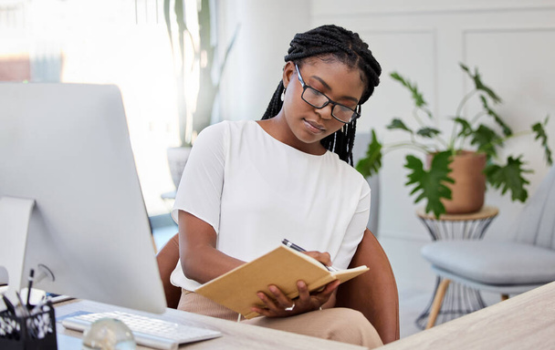 Business woman, computer and book for writing notes planning, agenda and office administration job. Black person, notebook and pc at desk to research ideas, information and web strategy online. - Photo, Image
