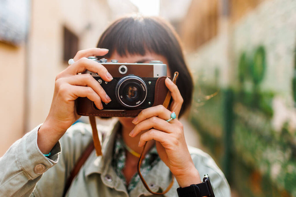 カメラを持った女性写真家が屋外で写真を撮ります. 若い女性写真家はレンズを目指し,撮影の過程を楽しんでいる. アラブ諸国に旅行する. 旅行と休暇について. - 写真・画像